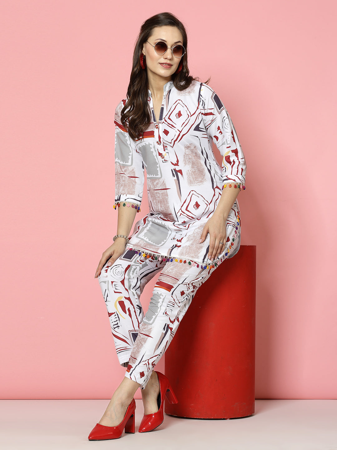 White abstract printed kurti and trousers set with geometric design, V-neck, and three-quarter sleeves.