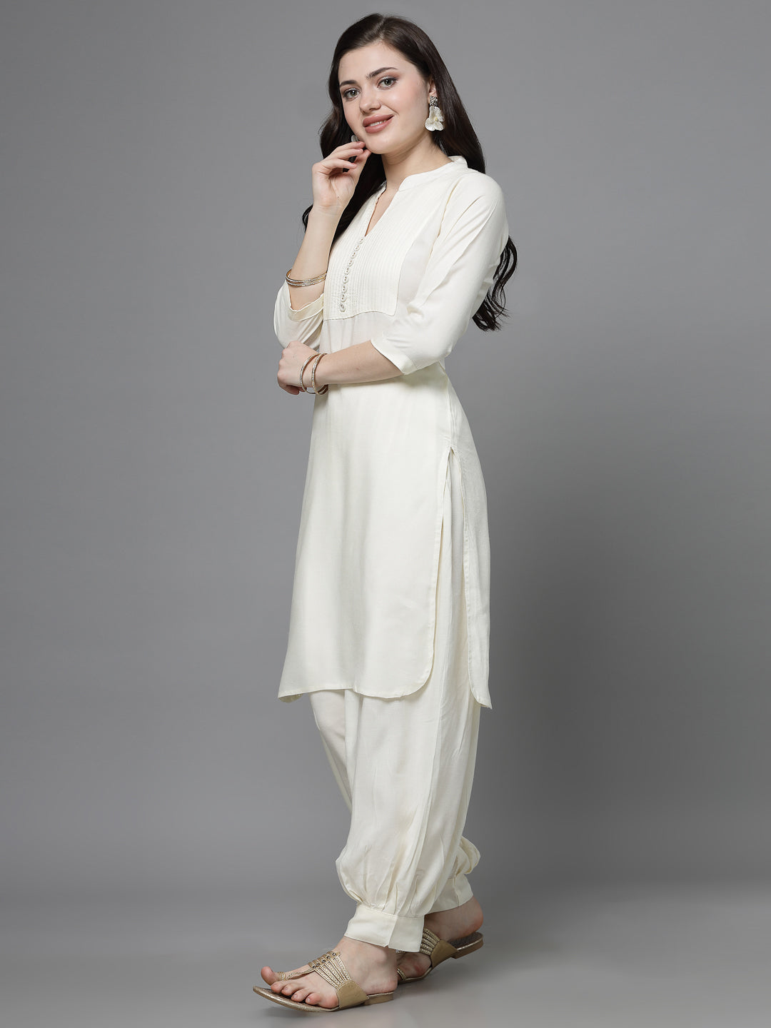 Yoke design kurta with Afghani pants in off-white, three-quarter sleeves, mandarin collar, and curved hemline.