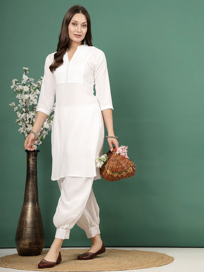 Yoke design white kurta with Afghani pants, featuring mandarin collar and three-quarter sleeves.