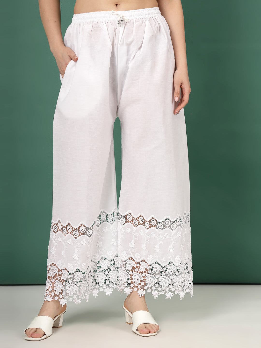 White palazzo pants with lace accent and intricate cut work hem design.