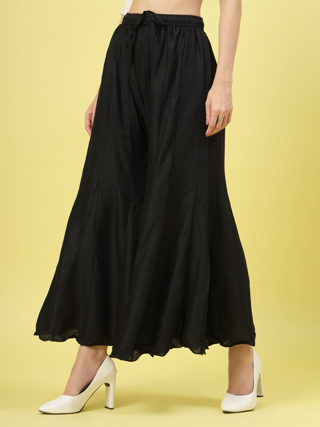 Women solid black flared rayon sharara with elasticated waistband and drawstring closure.