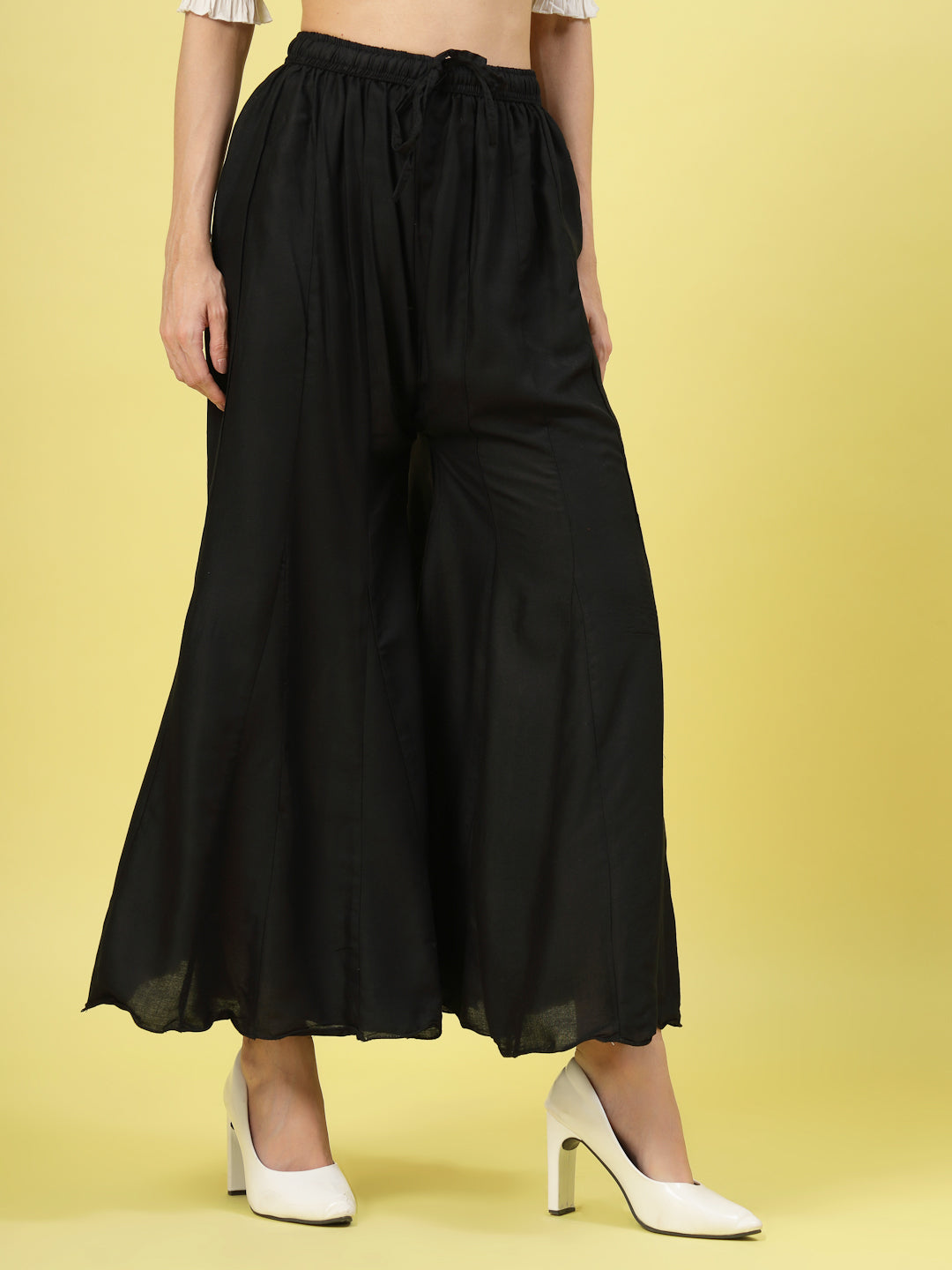 Women solid black flared rayon sharara with elasticated waistband.