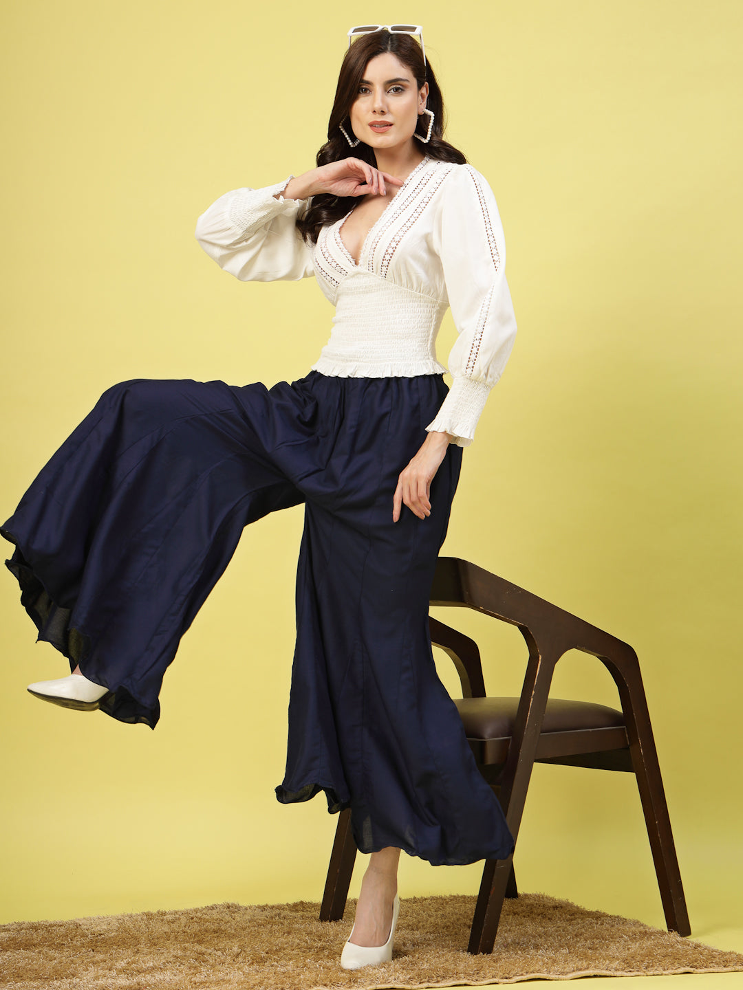 Women wearing solid navy blue flared rayon sharara with elasticated waistband and drawstring closure.