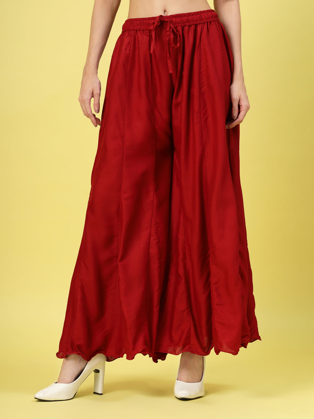 Women solid maroon flared rayon sharara with elasticated waistband and drawstring closure.