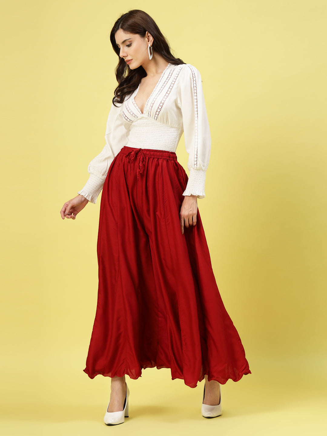 Women wearing solid maroon flared rayon sharara with elasticated waistband and drawstring closure.