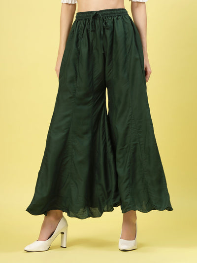 Women solid bottle green flared rayon sharara with elasticated waistband and drawstring closure.