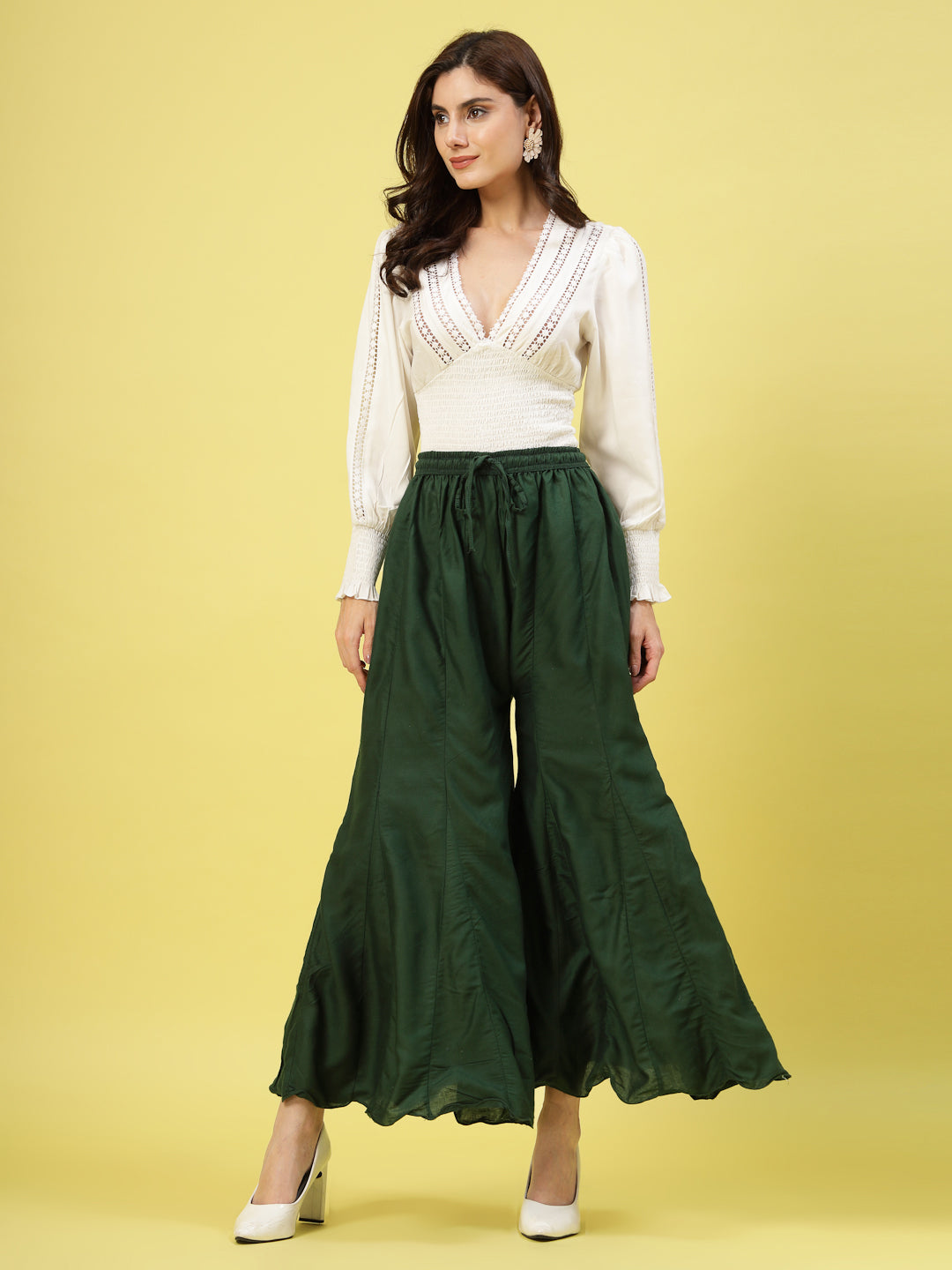 Women wearing solid bottle green flared rayon sharara with elasticated waistband.