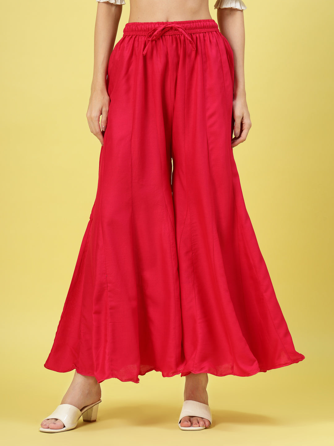 Women Solid Red Flared Rayon Sharara with elasticated waistband and drawstring closure.