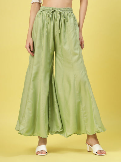 Women solid pista green flared rayon sharara with elasticated waistband and drawstring closure.