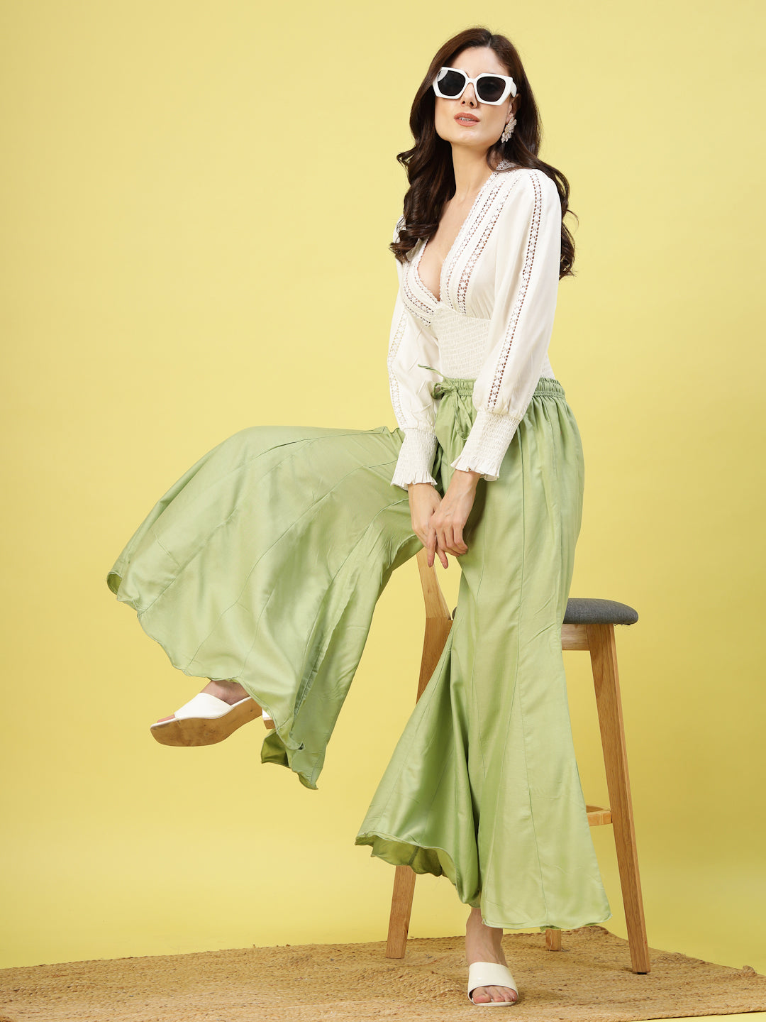 Women wearing solid pista green flared rayon sharara with elasticated waistband.