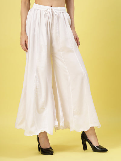 Women solid white flared rayon sharara with elasticated waistband and drawstring closure.