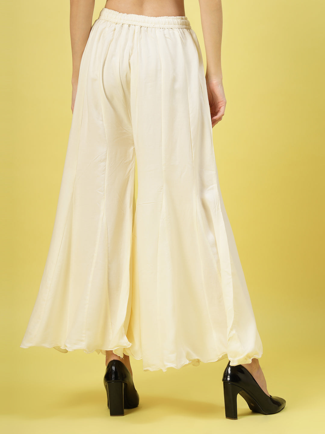 Women solid cream flared rayon sharara with elasticated waistband.