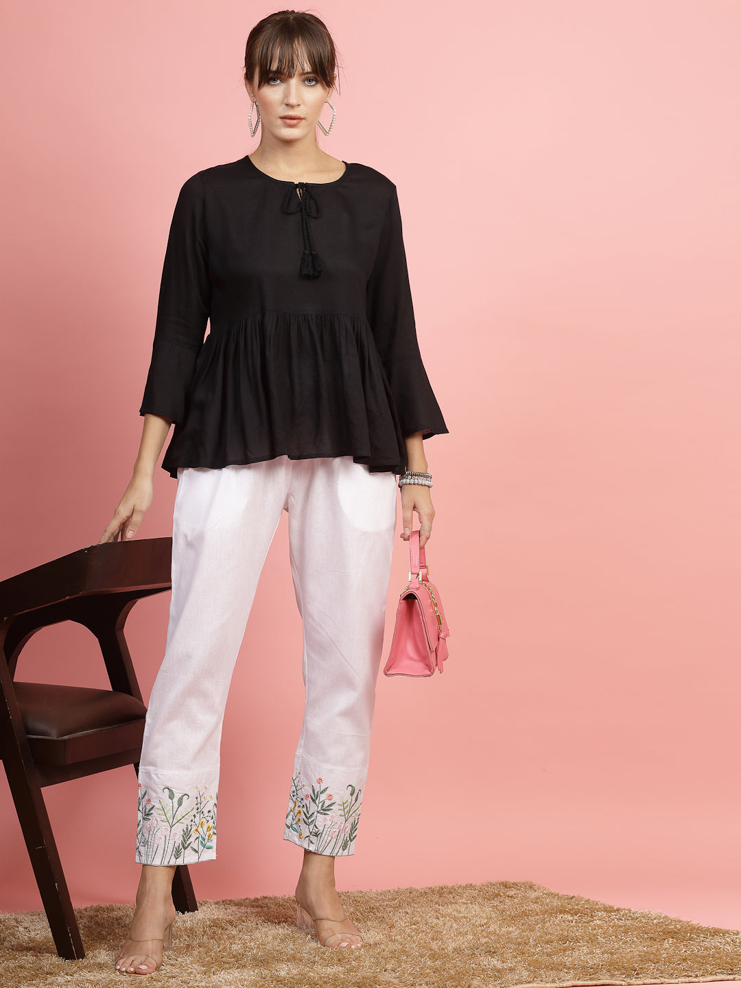 Women mid-rise pants with embroidered hem and regular fit design.