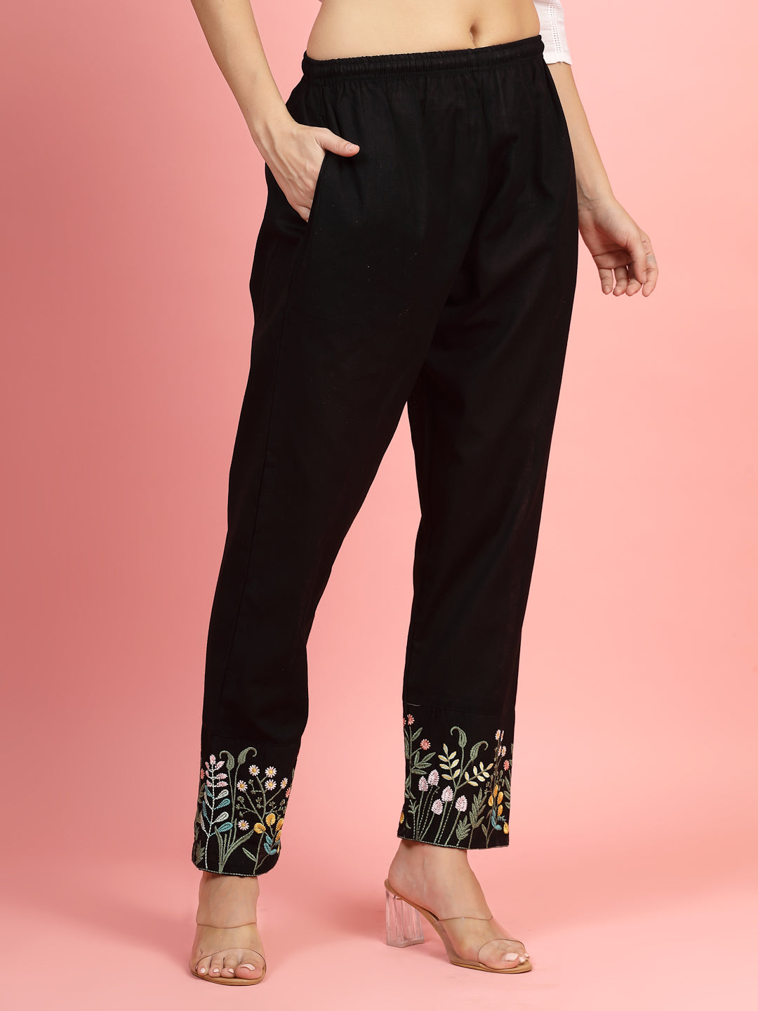 Women embroidered hem design mid-rise pants with floral pattern and pockets.