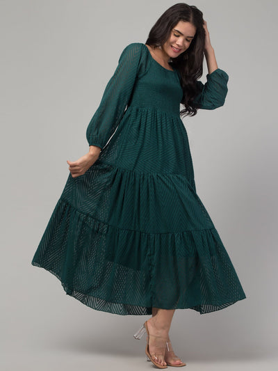 Women wearing a bottle green printed fit and flare dress made of Georgette fabric.