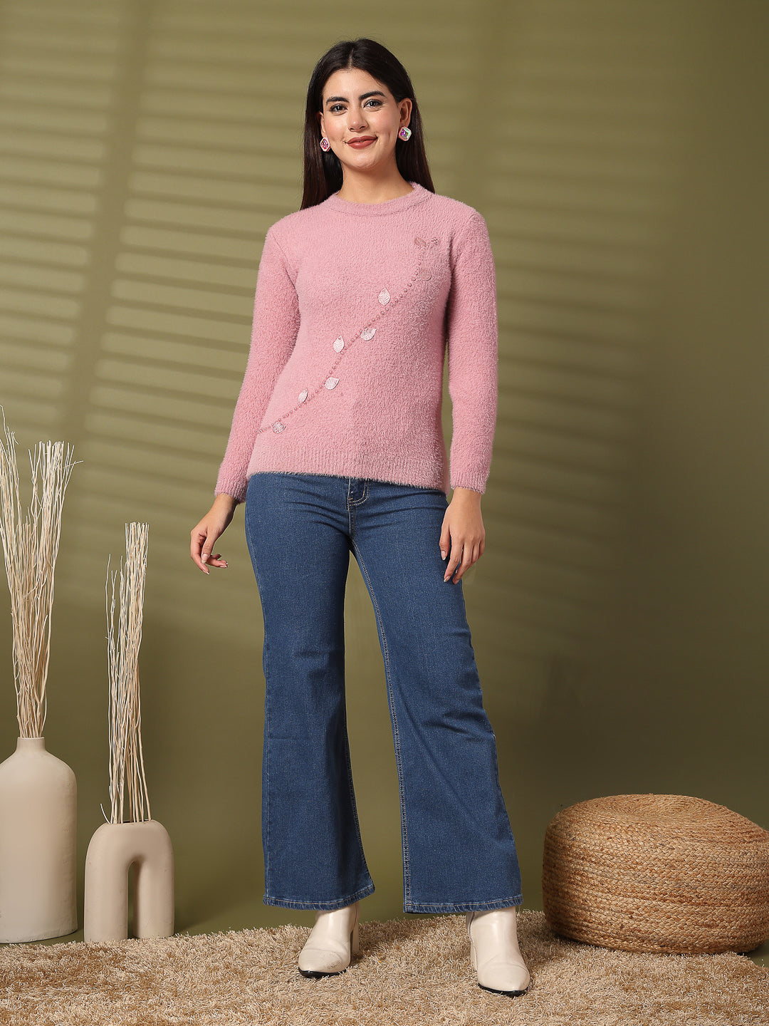 Pink embellished woolen top with full sleeves worn with jeans in a cozy setting.