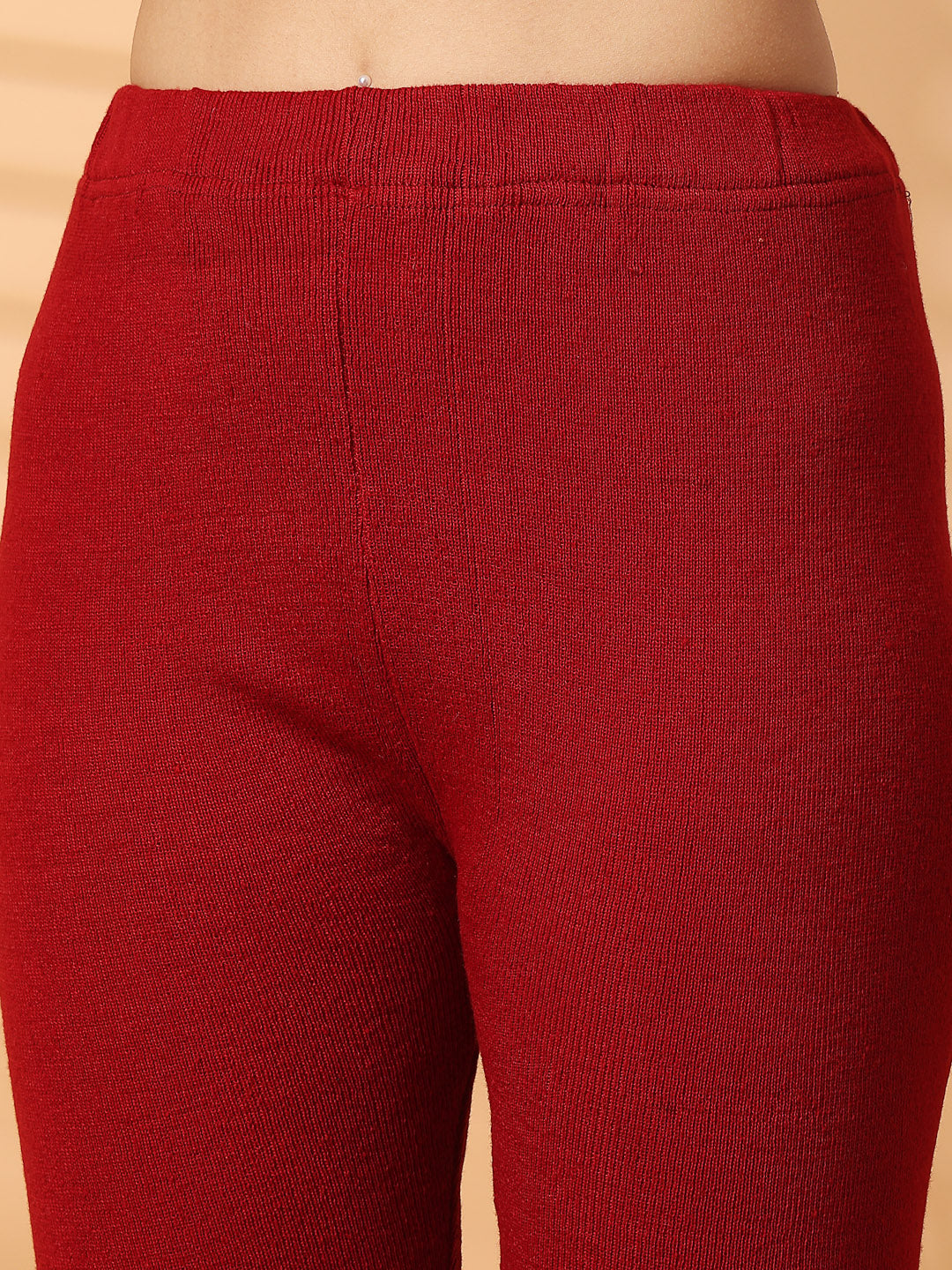 Women maroon solid woolen leggings with unique hem design.