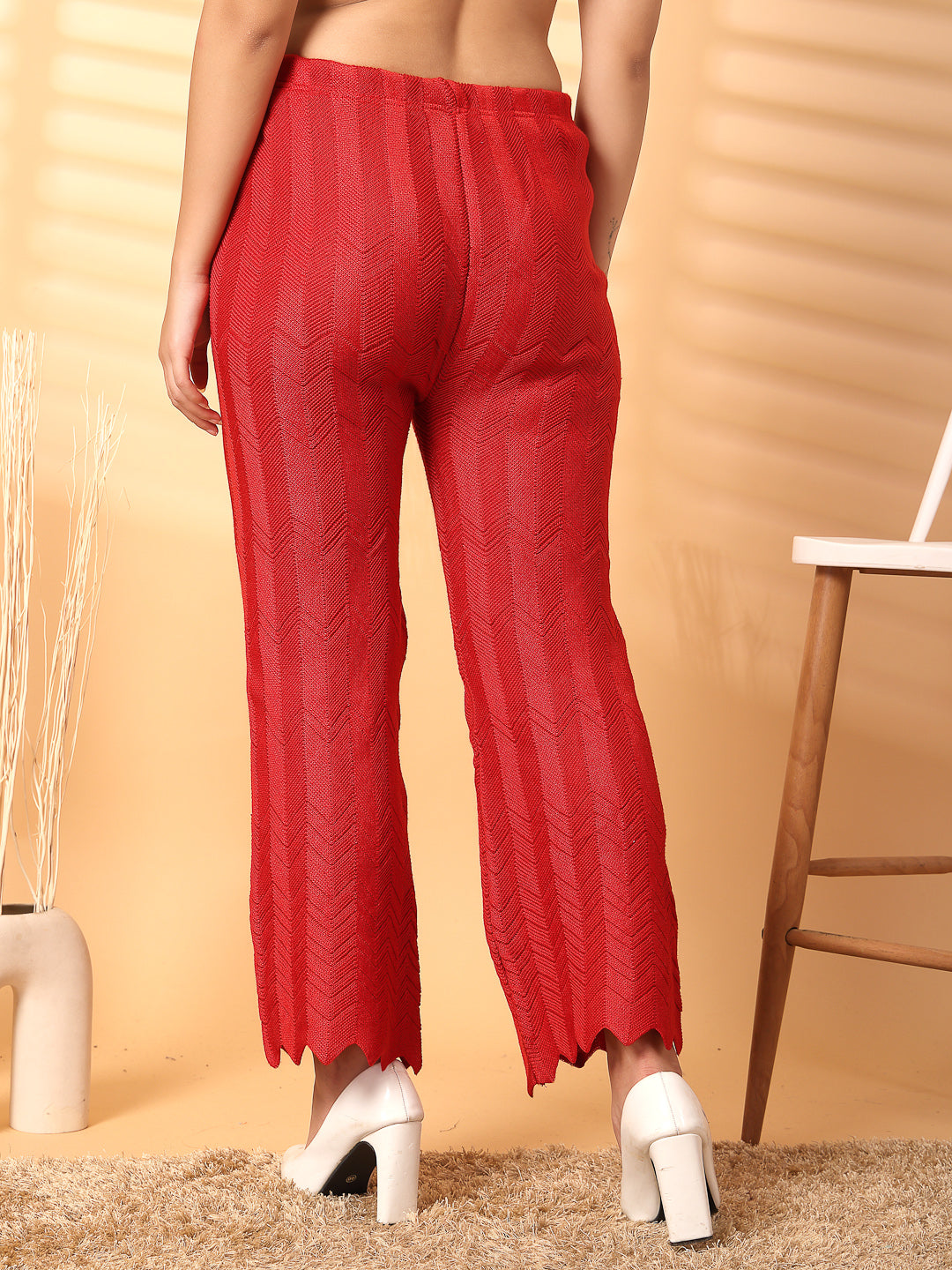 Red solid woolen palazzo with intricate cut work detailing at hemline for elegant winter style.