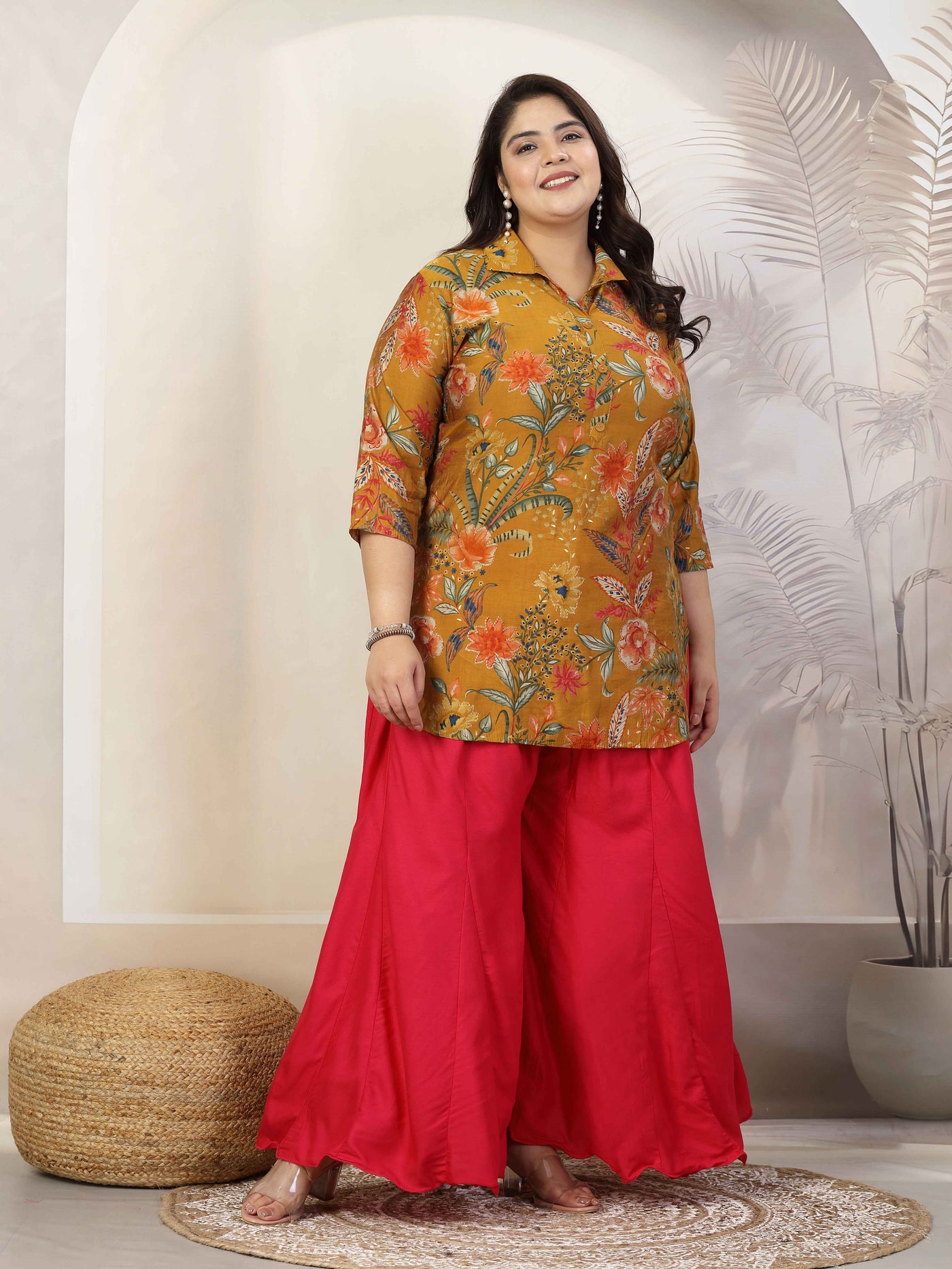 Plus size women in solid red flared rayon sharara with elasticated waistband and drawstring closure.