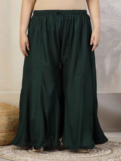 Women solid bottle green flared rayon sharara with elasticated waistband and drawstring closure.