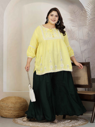 Women wearing a solid bottle green flared rayon sharara with elasticated waistband and drawstring closure.