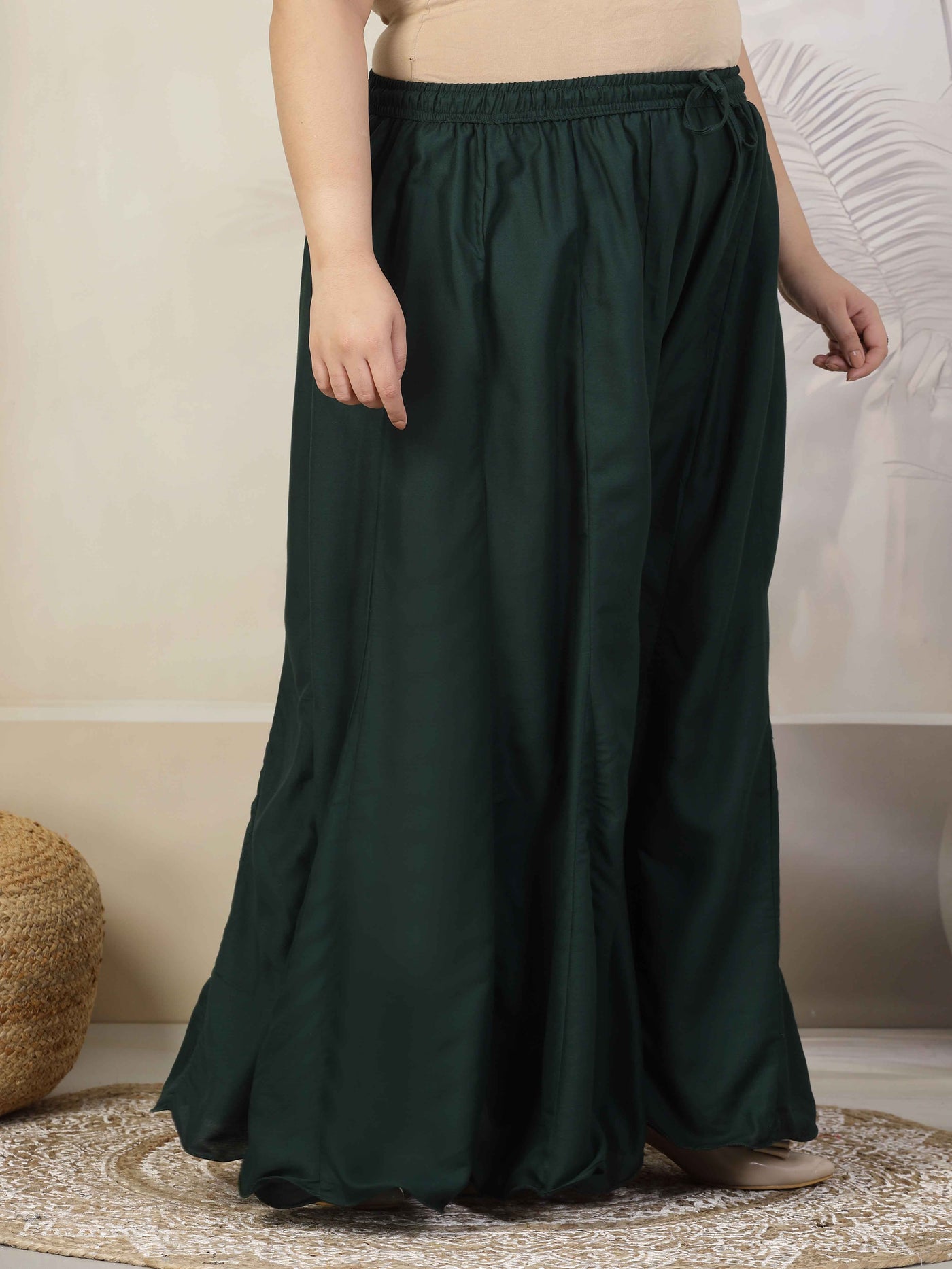 Women solid bottle green flared rayon sharara with elasticated waistband.