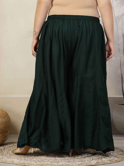 Women solid bottle green flared rayon sharara with elasticated waistband and drawstring closure.