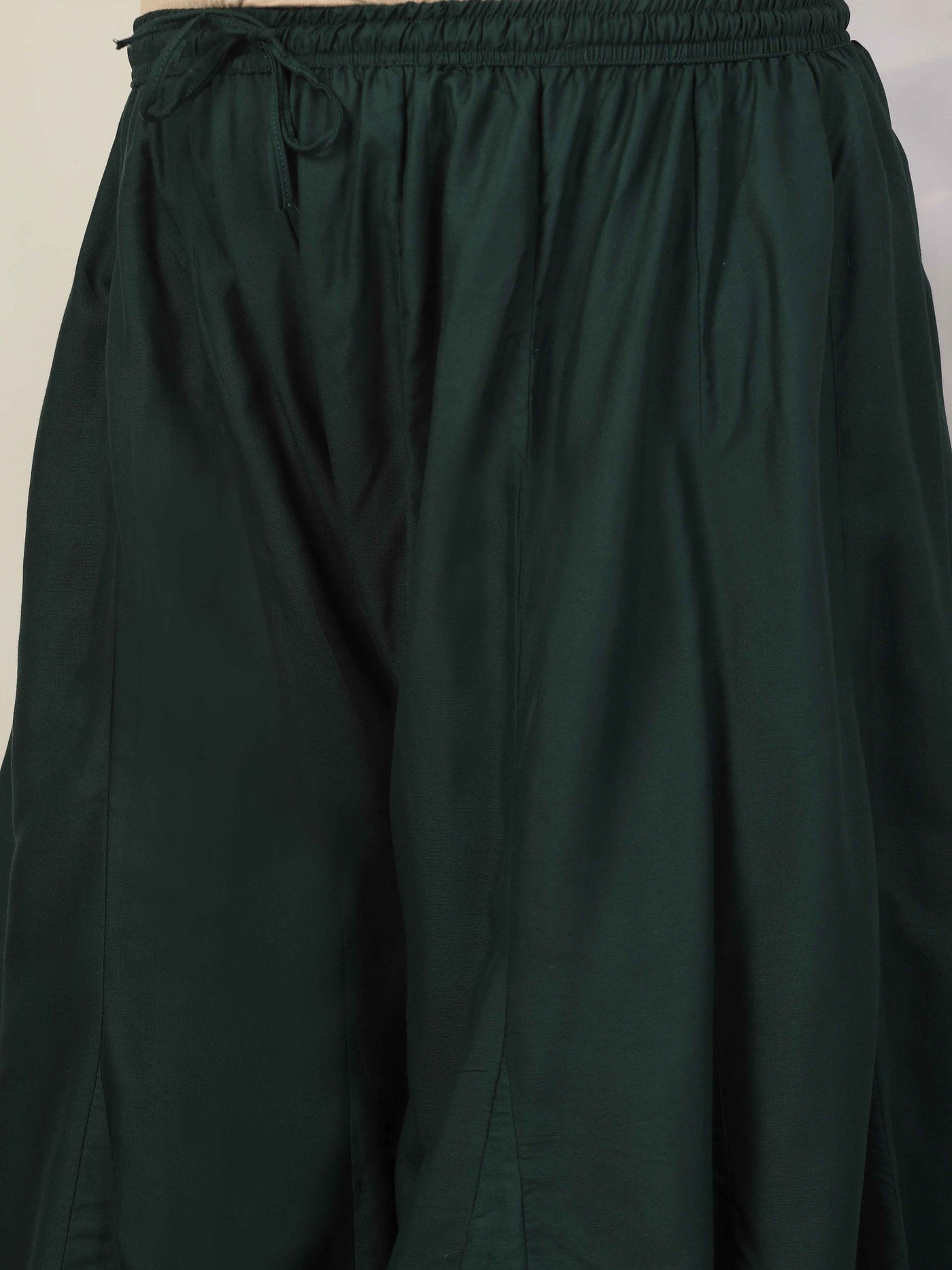 Women solid bottle green flared rayon sharara with elasticated waistband.