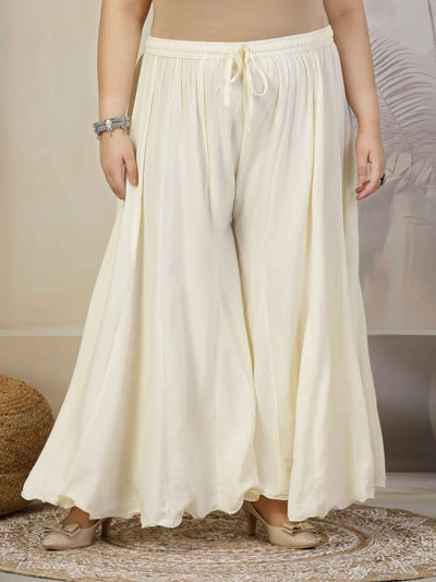 Women solid cream flared rayon sharara with elasticated waistband and drawstring.