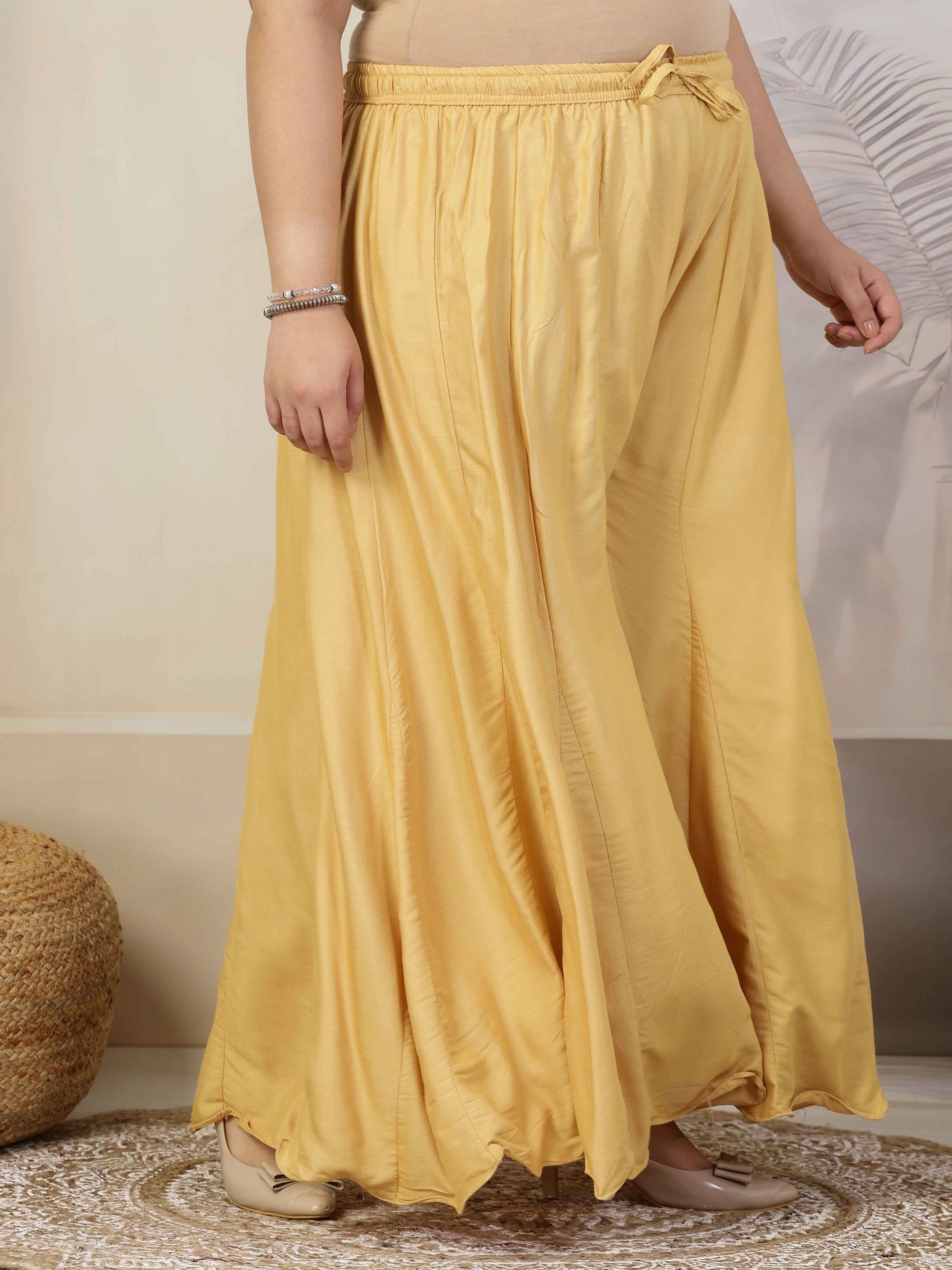 Women solid fawn flared rayon sharara with elasticated waistband and drawstring closure.