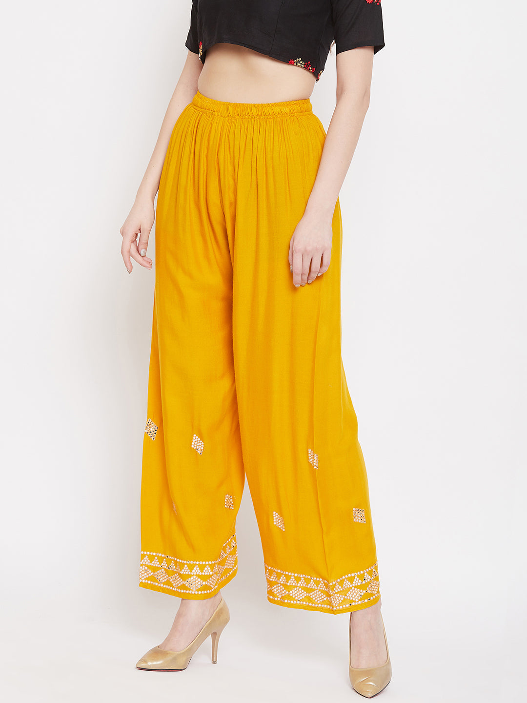 Mustard embellished rayon palazzo with elastic waistband and mirror work hem.