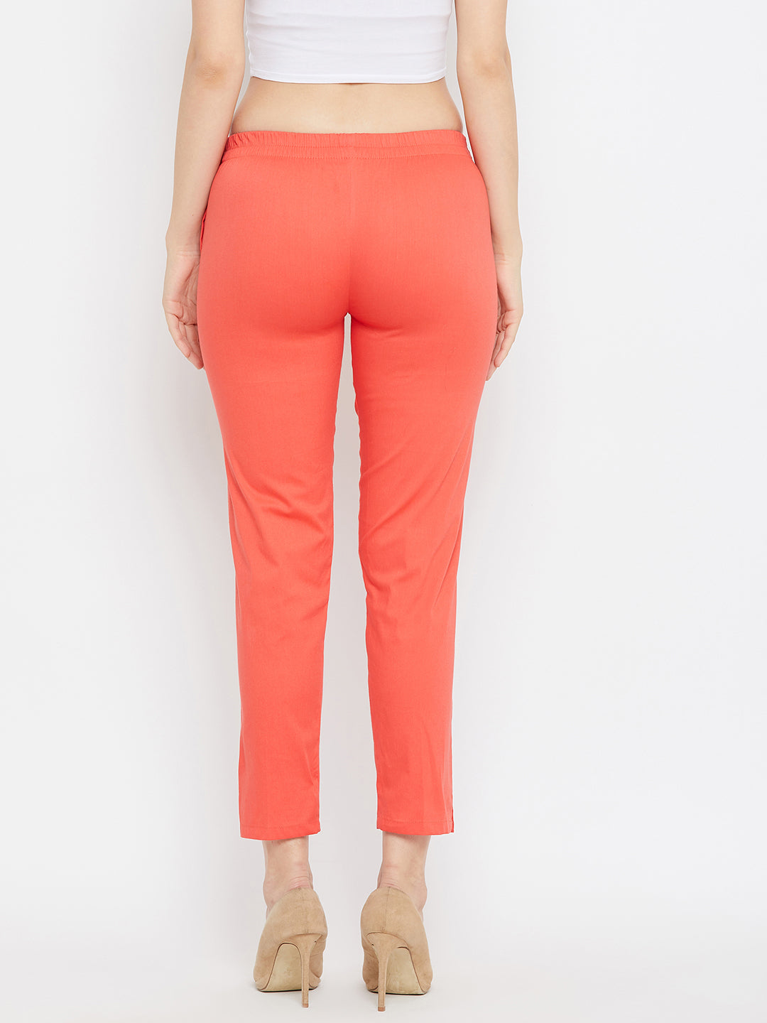 Peach regular fit solid pants for women made from lightweight cotton fabric.