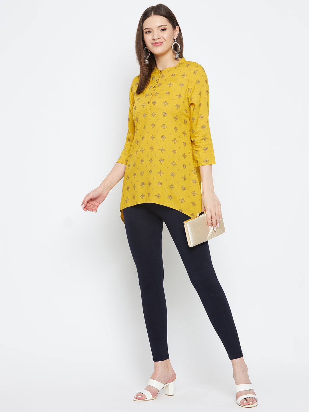 Navy blue solid ankle-length leggings paired with a yellow kurta and white heels.