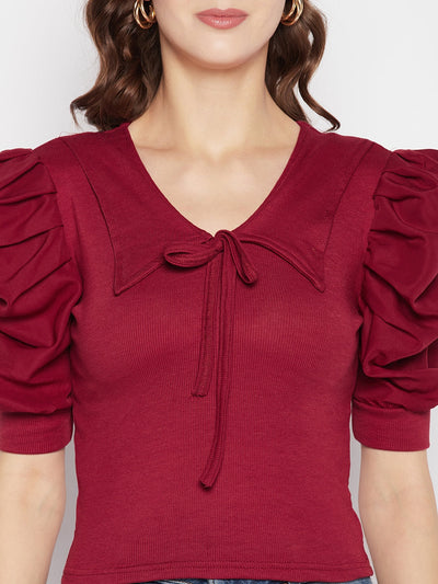 Maroon solid puff sleeves crop top with tie knot collar and knitted fabric.