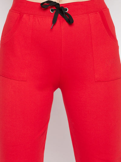 Red solid mid rise cotton trackpants with elasticated waistband and drawstring closure.