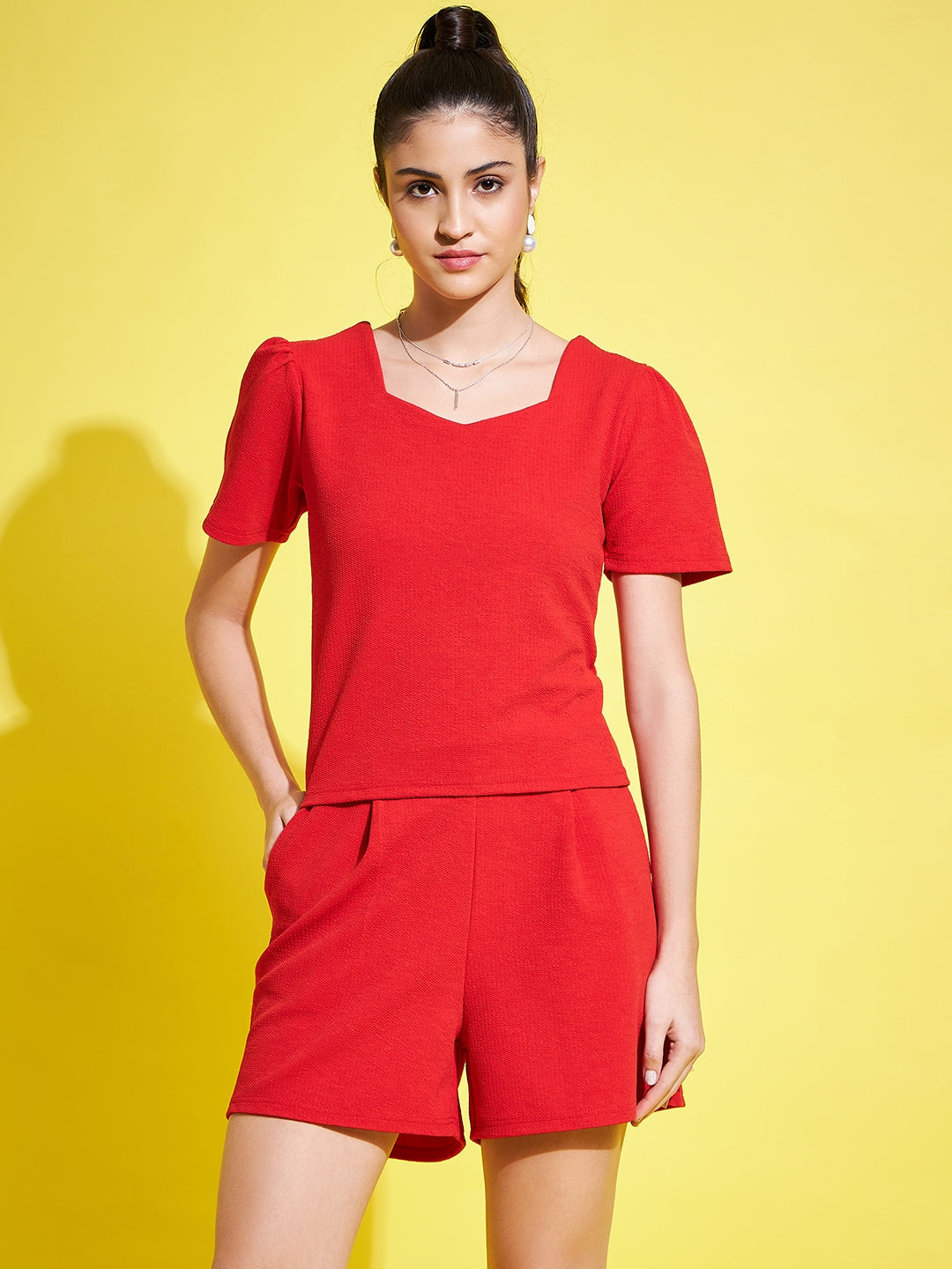 Red solid regular fit top with V-neck and half sleeves.