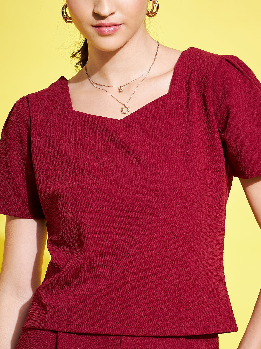 Maroon self-design top with V-neck and short sleeves.