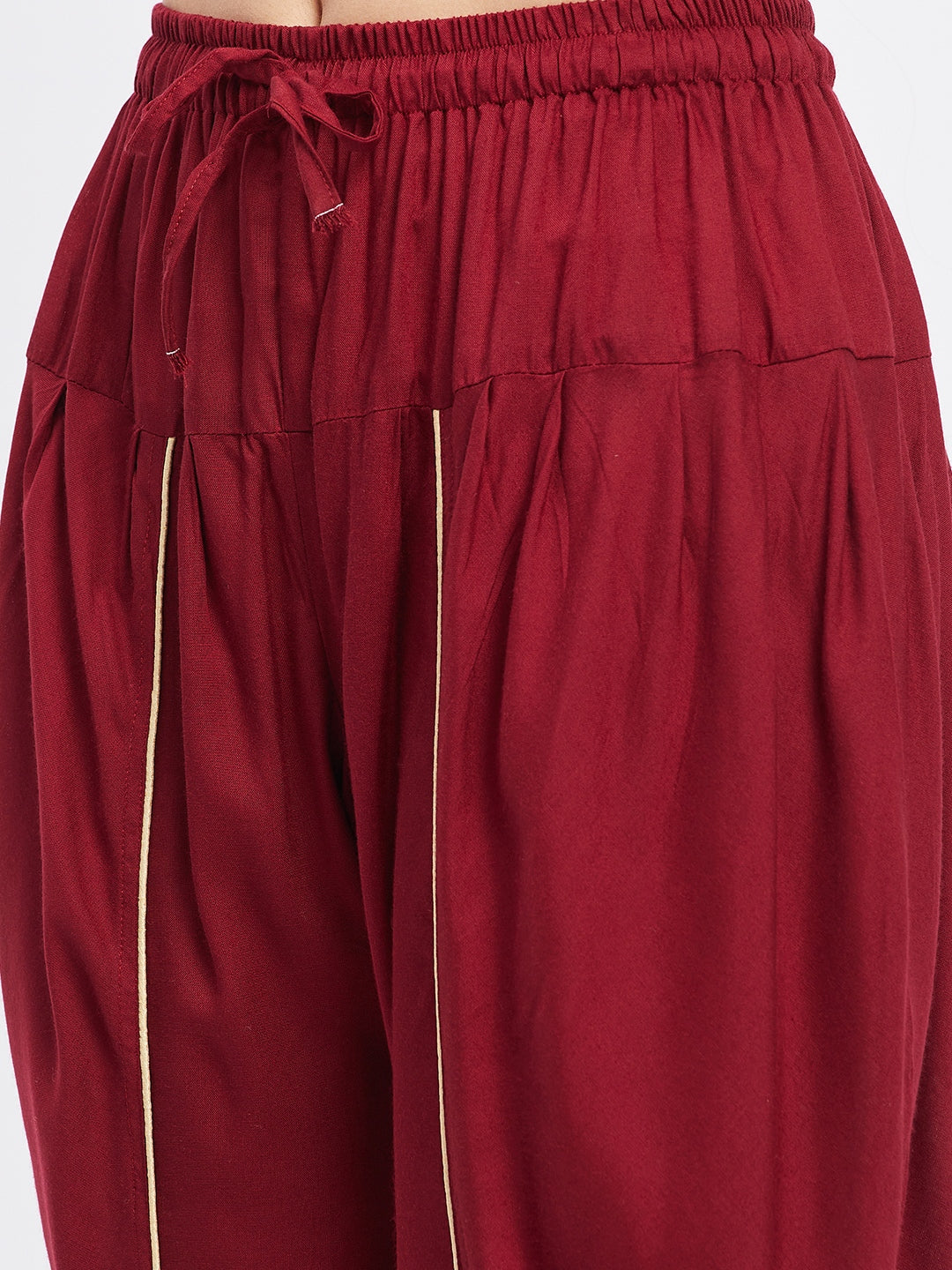 Maroon solid rayon tulip pant with elasticated waistband and drawstring.