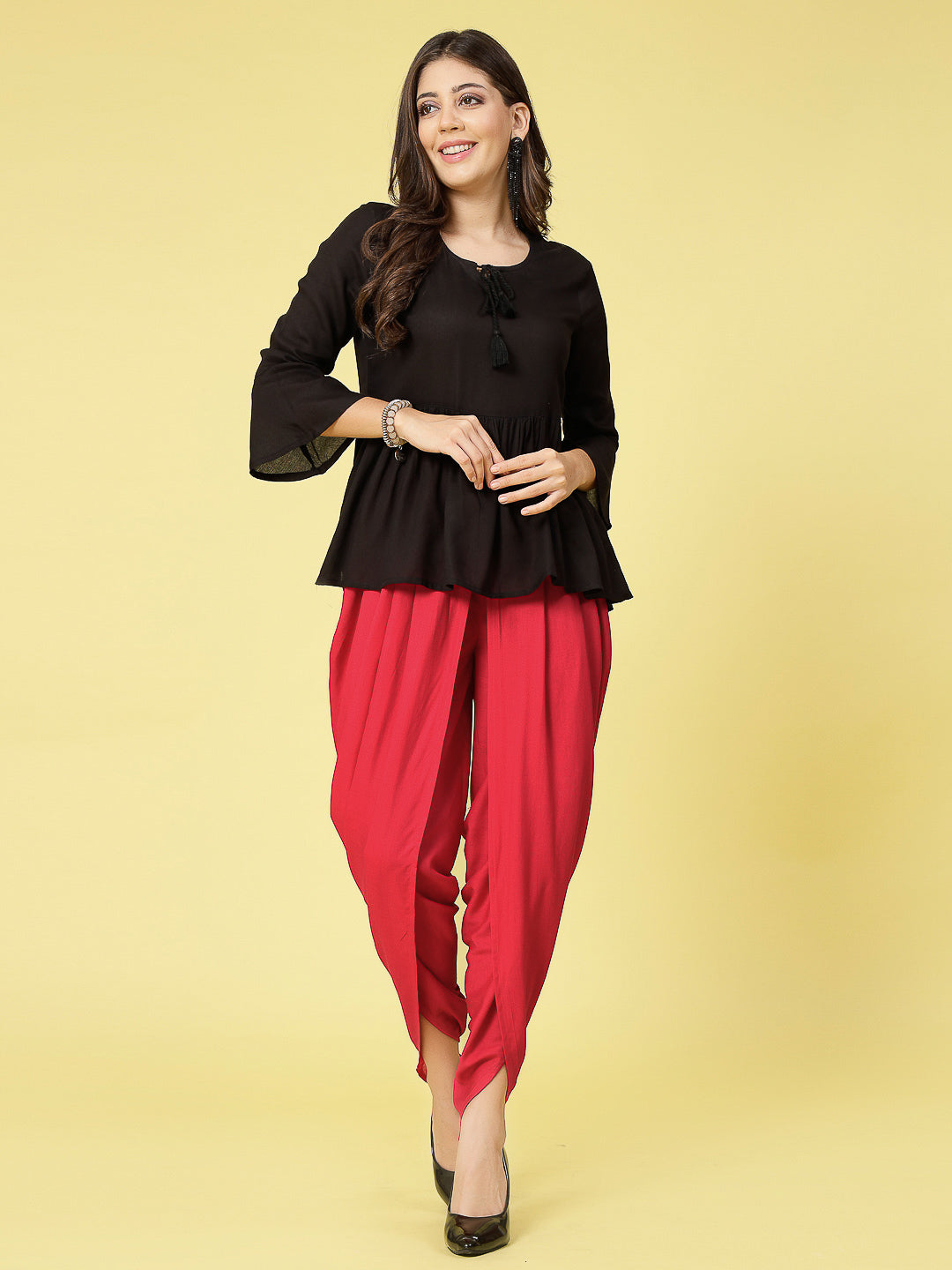 Women wearing a bright red rayon dhoti salwar with gathered pleats and elastic waistband.