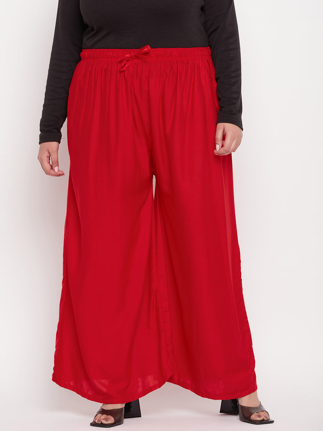 Red solid rayon jumbo sharara with elasticated waistband and drawstring.