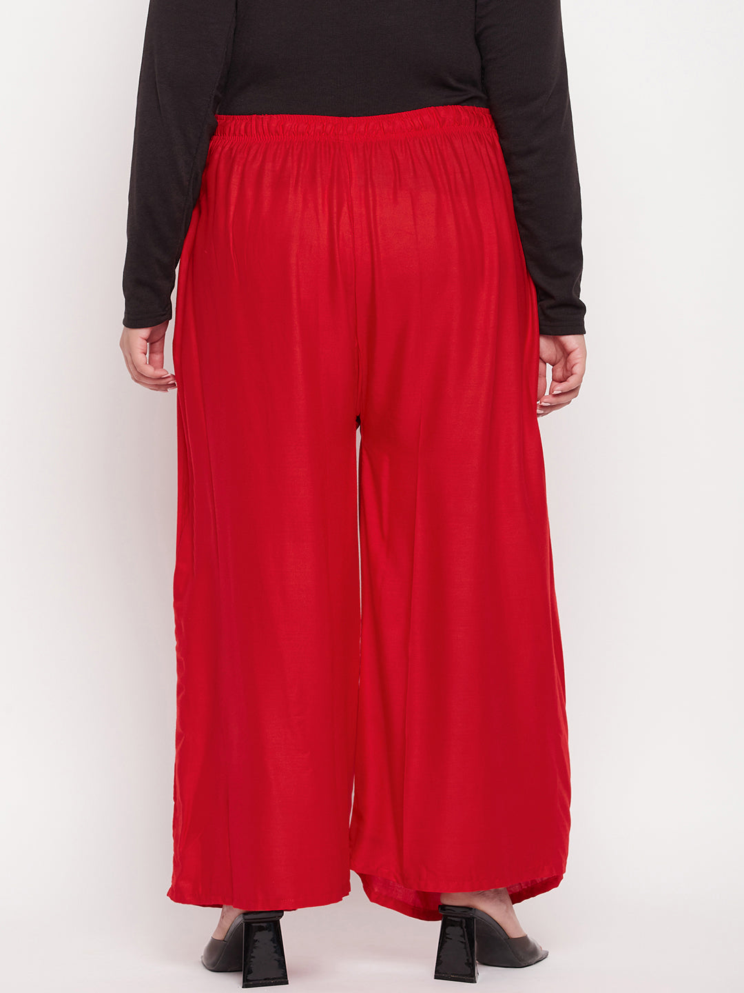 Red solid rayon jumbo sharara with elasticated waistband and drawstring.