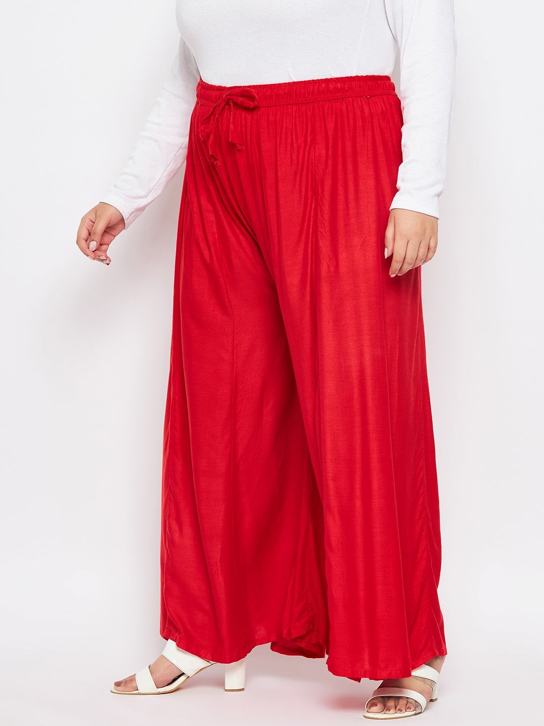 Red solid rayon flared sharara with elasticated waistband and drawstring.