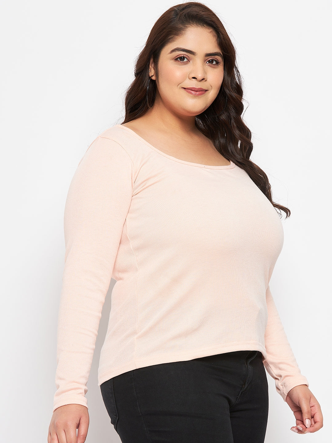 Plus-size model wearing peach solid full sleeves top made of polyester, cotton, and elastane.